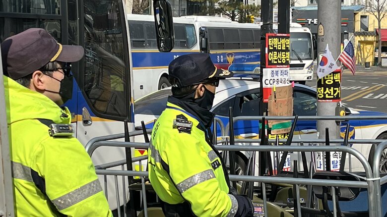 個人を特定されないよう顔を隠す警察官