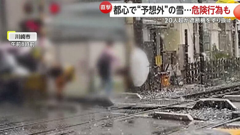 警報音が鳴る中、遮断機をすり抜け、20人以上が踏み切りを横断