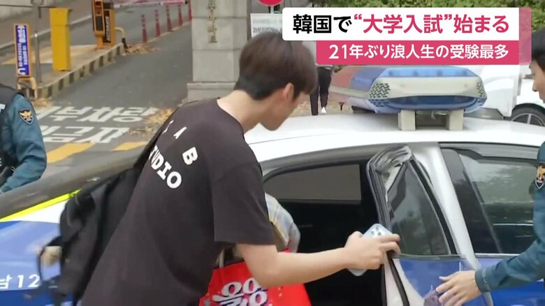 パトカーで会場入りする受験生