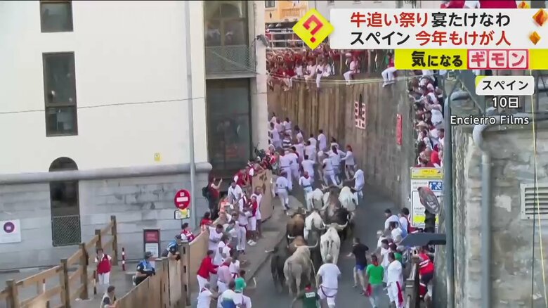 牛に追われ、男性たちが逃げる