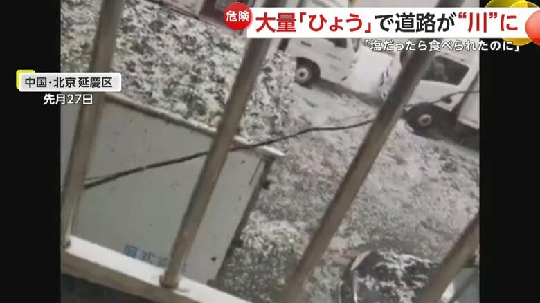 道路を埋め尽くしたひょうが、川のように流れていく様子