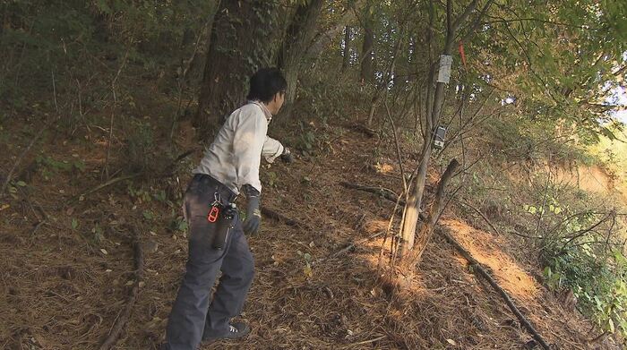 わなを設置した場所を指す桜井さん