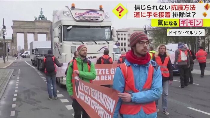 トラックのクラクションにも構わずデモを続ける環境活動家たち