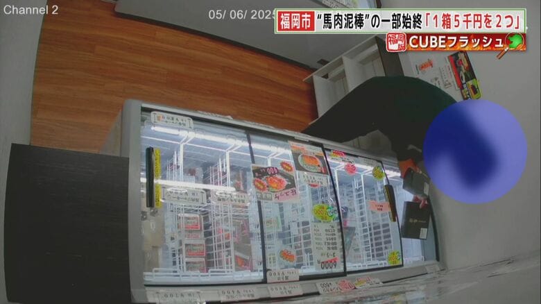 男はショーケースから商品を2つ取り出す