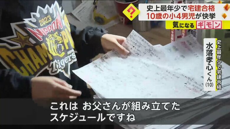 父親が組み立てたというスケジュールを見せる孝心くん