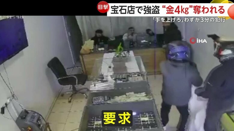 従業員らに銃を突きつける強盗犯