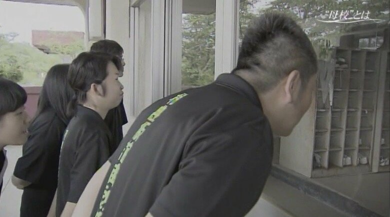 本校舎の中を覗く演劇部員と先生