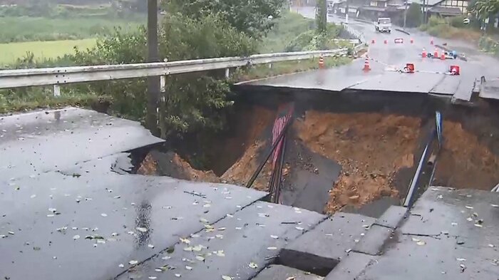 陥没した道路。横に流れる水路が詰まり、雨水が流れ出したという(京都・福知山市 午後0時半ごろ)