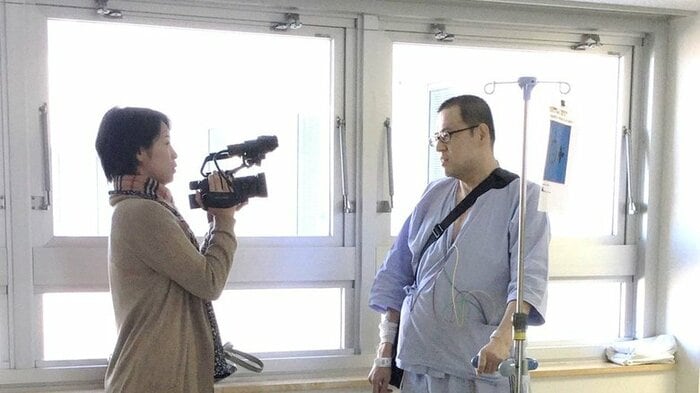 取材を受けるバド仲間のクマさん 左は制作を担当した八木里美ディレクター