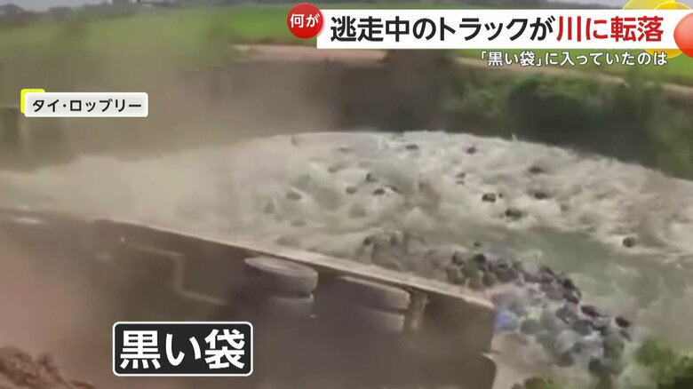 積んでいた荷物が散乱し、川へ流れ込んでいった大量の黒い袋