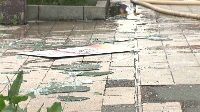 爆発で歩道にガラスが散らばる