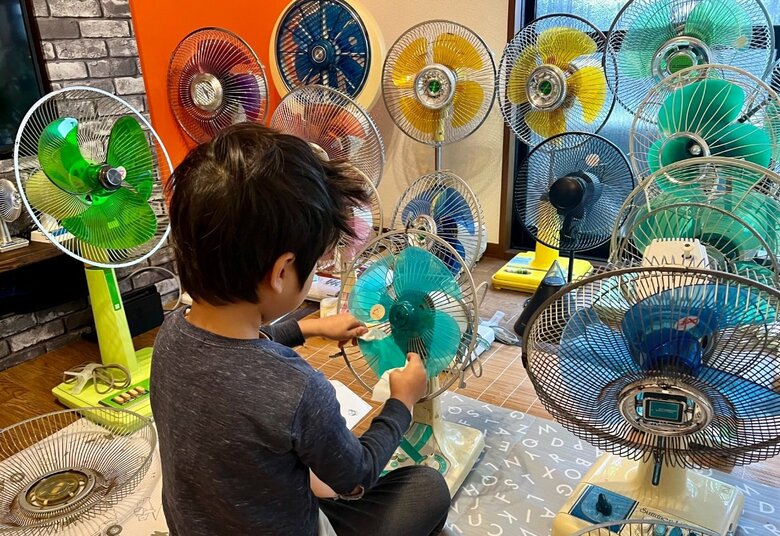 3年経った現在の写真。ずらりと並んだ扇風機コレクションと成長した息子さん