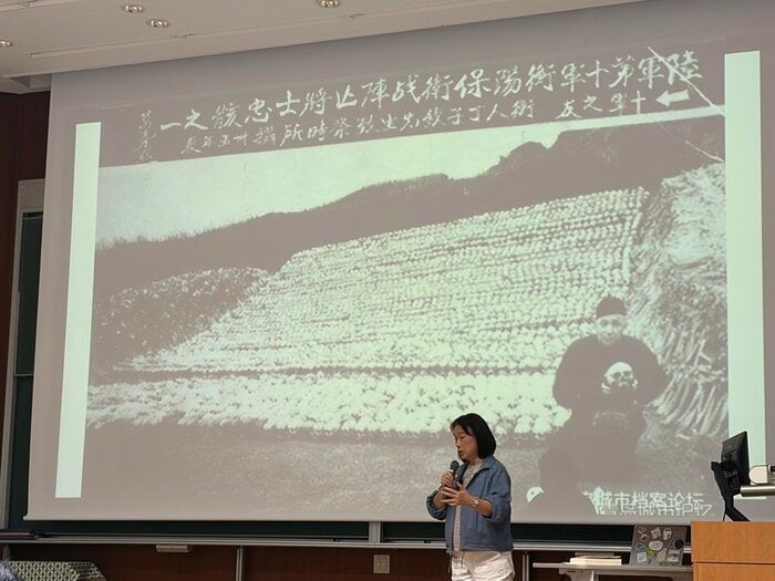 講演時の龍應台氏　画面は兵士の白骨