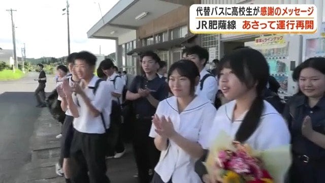 拍手でバスを迎える高校生たち