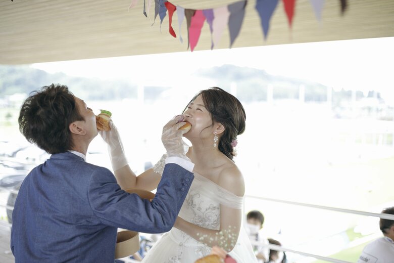 祝福ムードに笑顔をみせる新郎新婦（提供元：テゲバジャーロ宮崎）