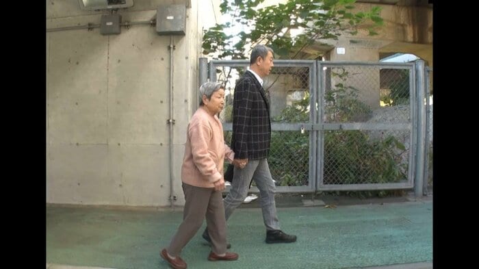 母親と散歩する江蔵さん(2018年撮影 弁護団提供)