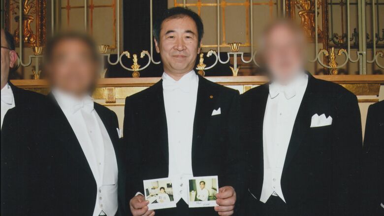 戸塚さんの写真を掲げる梶田教授
