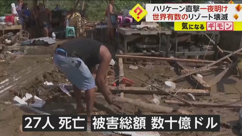 ハリケーンによって倒壊した建物跡で、がれきを片付ける人