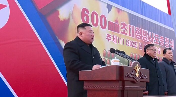 「600mm超大型放射砲贈呈式典」で演説する金正恩総書記。後ろに「600mm」の文字。(KRT朝鮮中央テレビ・1月1日より)