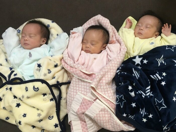 退院直後の三つ子 同じバンザイポーズをしている
