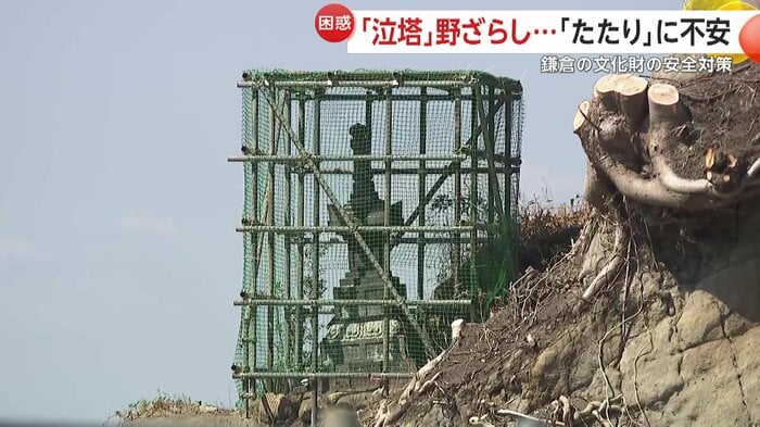 無数の鉄パイプとネットに囲まれていた市の指定有形文化財「泣塔」