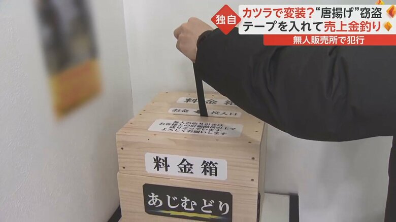 テープを料金箱の投入口のわずかな隙間から中に入れ…