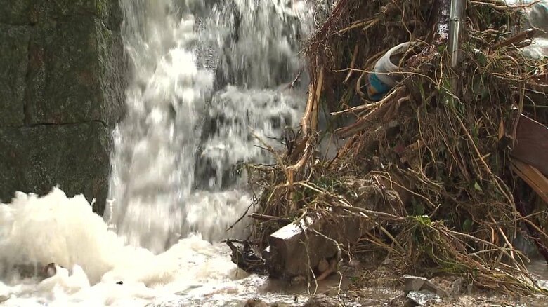 階段を激しく流れる濁流と絡みつく流木