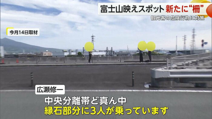 中央分離帯の縁石部分に乗った3人