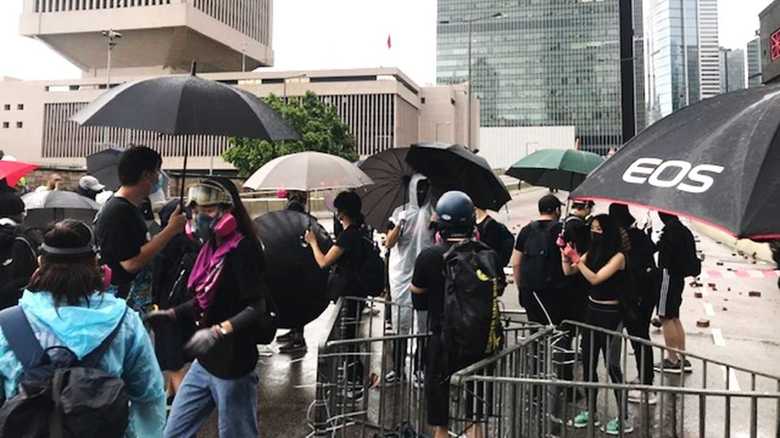 警官隊との衝突に備え「勇武派」がバリケードで道路を封鎖する 正面右の建物が政府総部、左が中国人民解放軍駐香港部隊のビル