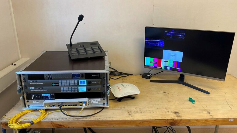 会場外のプレハブ小屋からカメラマンに指示を送った