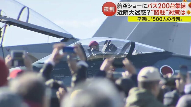 来場者に向けて片手を上げるパイロット