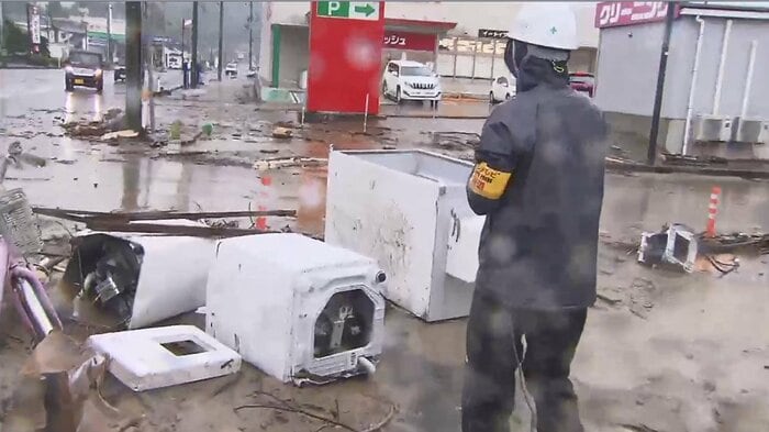 泥まみれになった洗濯機や冷蔵庫などが交差点に流された(京都・福知山市大江町 正午前)
