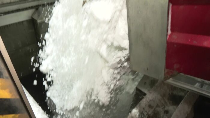 地上ではダンプカーがプールへと雪を降ろす