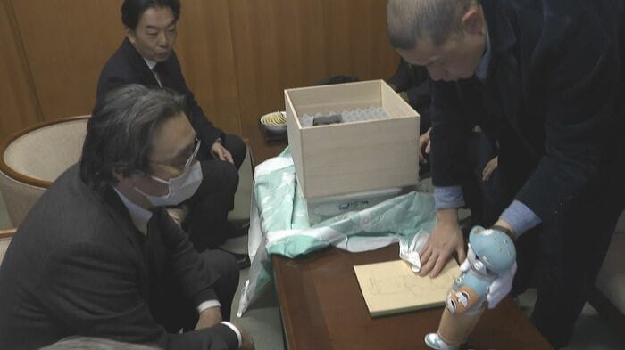 柿右衛門さんに試作の人形とスケッチを見せる中村さん
