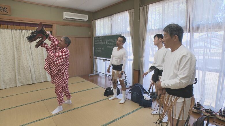 獅子頭の説明を聞く"お助け隊"