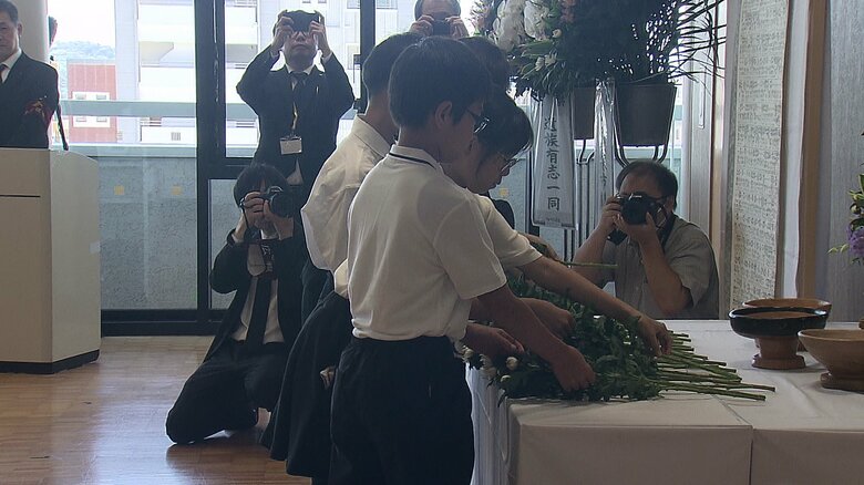 献花式で花を手向ける子どもたち