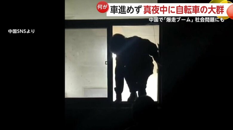 窓を乗り越えて外に出る学生