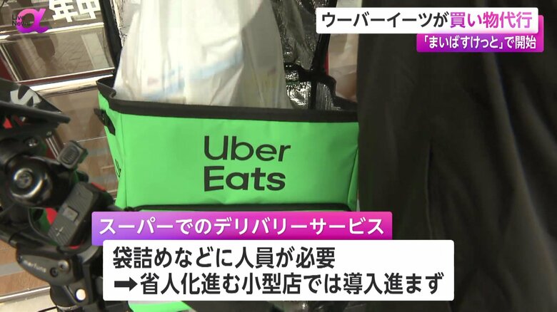 袋詰めした商品を後ろの荷台に入れるUber Eatsの配達員