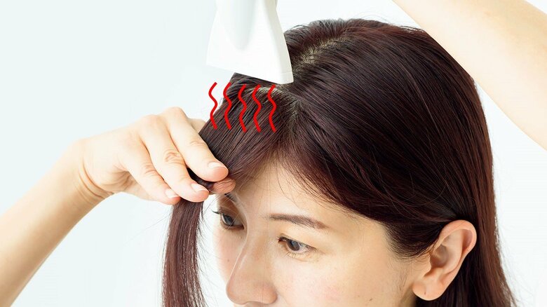 マッサージで美容液をなじませトリートメントウォーターをつけたら、クセを伸ばしながら乾かす。最後は冷風を当てる