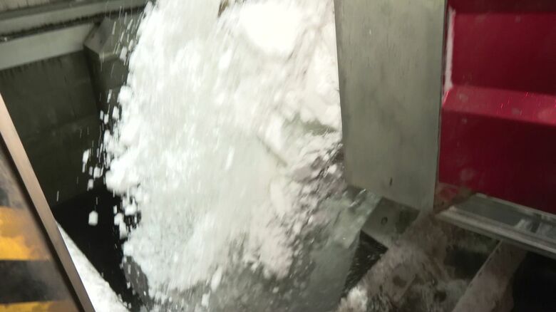 地上ではダンプカーがプールへと雪を降ろす