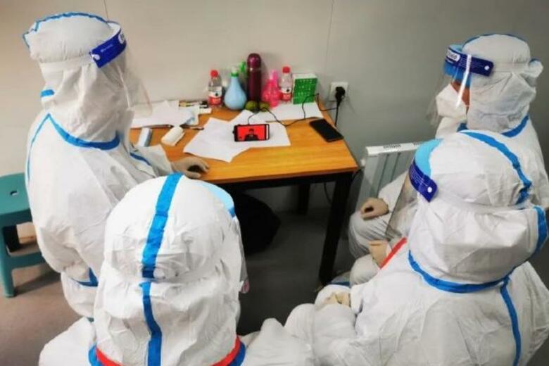 防護服を着ながら党大会を見るPCR検査の係員（ウェイボより）