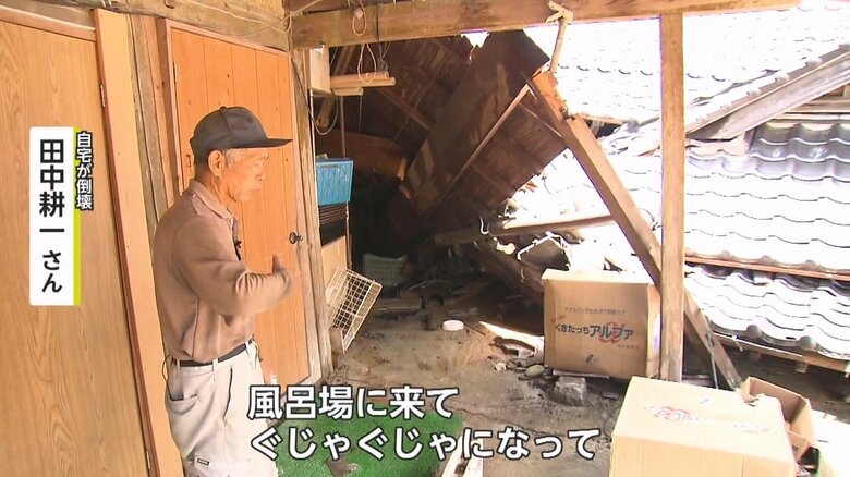 倒壊した自宅を前に当日の様子を語る田中さん