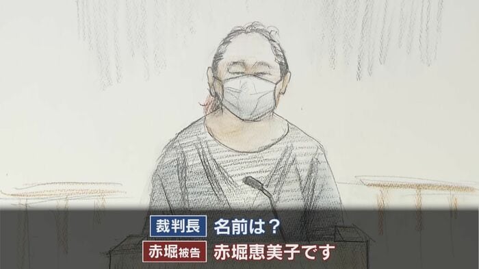 紺の長袖・長ズボン姿、落ち着いた様子で法廷に入ってきた