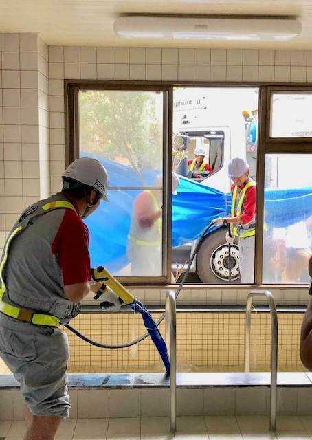 浴槽に作業車からのお湯を入れるスタッフ(13日、多古町)