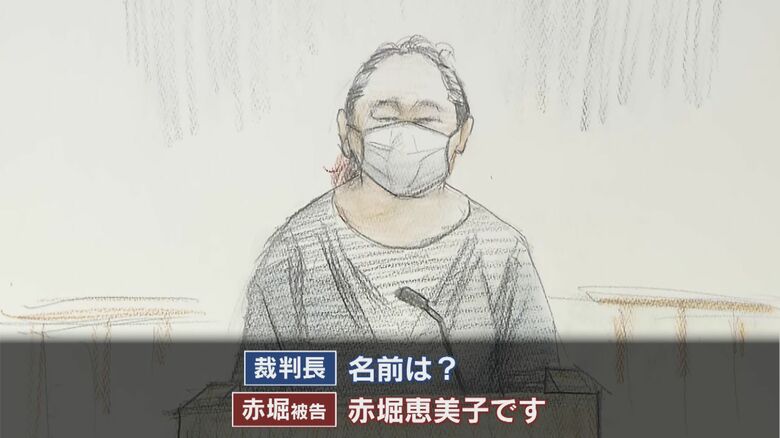 紺の長袖・長ズボン姿、落ち着いた様子で法廷に入ってきた