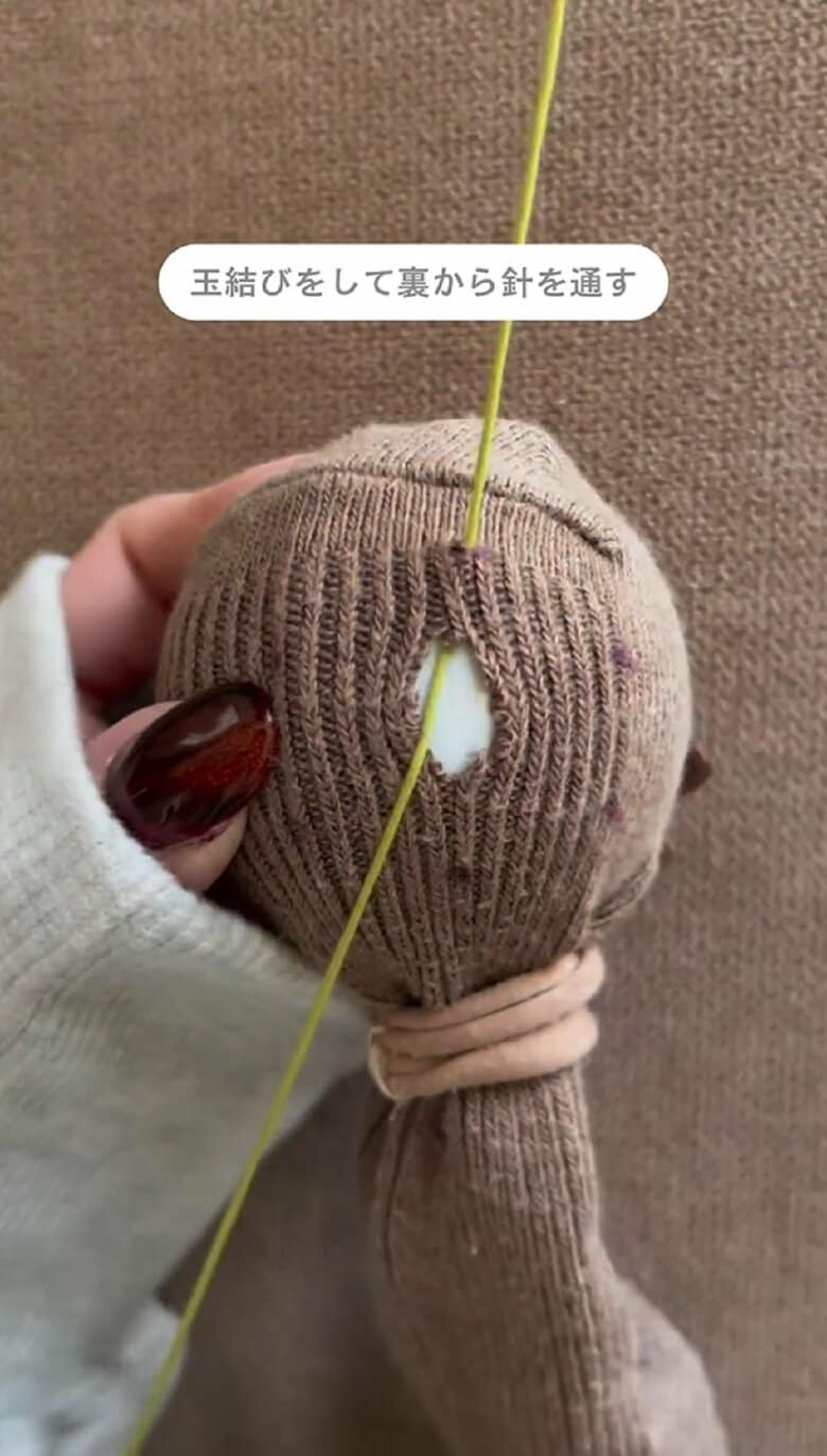 糸を通して玉結びをした針を靴下の裏側から通す
