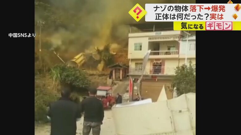 巨大な破片が転がり、住住宅近くにある筒状の物体から黄色い煙がモクモクと立ち上る様子