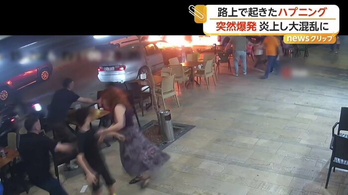 燃え上がる車から逃げる人々（IHA）