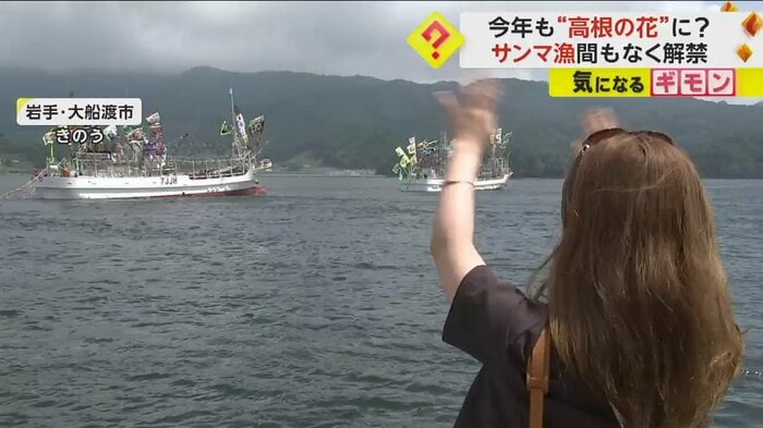 漁船に手を振って見送る