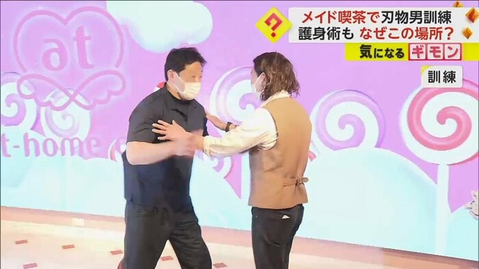 男性従業員が犯人役の男をなだめる